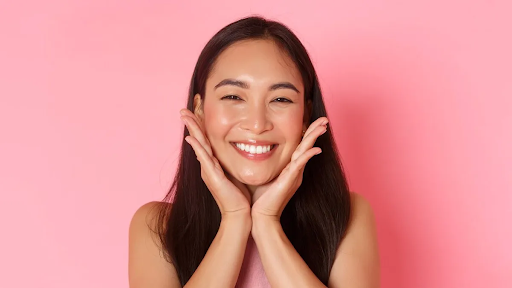 एक युवती जिसकी त्वचा कोरियन ग्लास स्किन की तरह चमक रही है और बाल बहुत रेशमी और काले हैं।